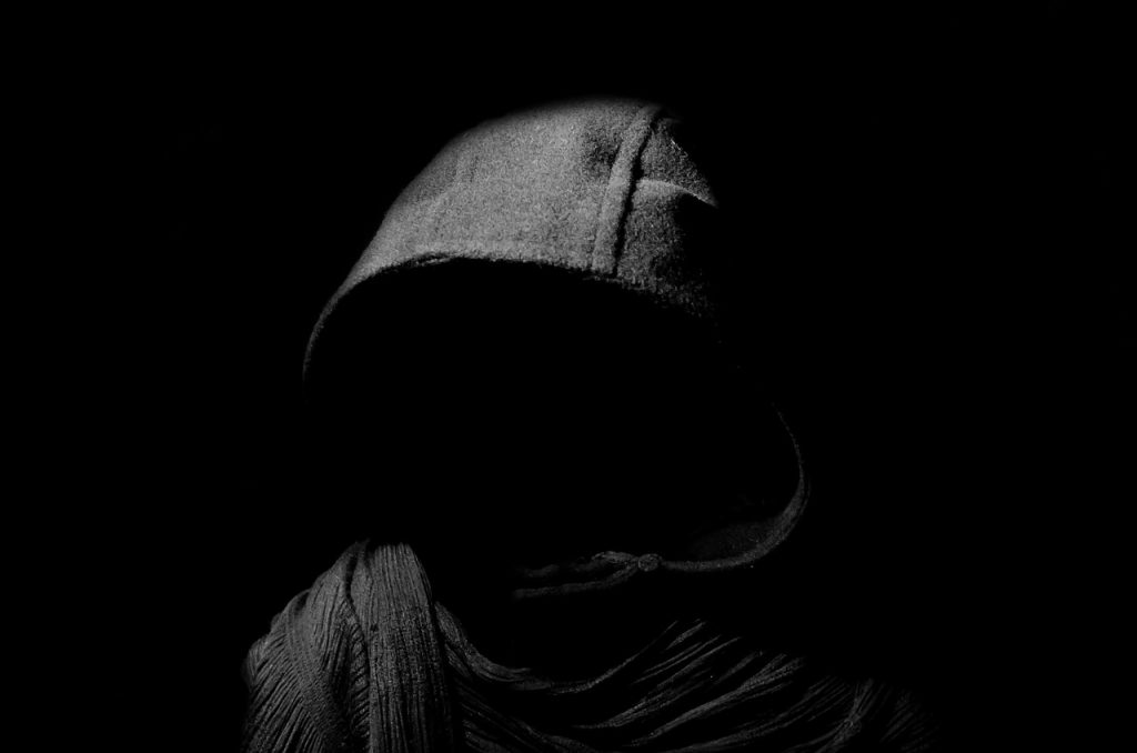 Cloaked figure in darkness