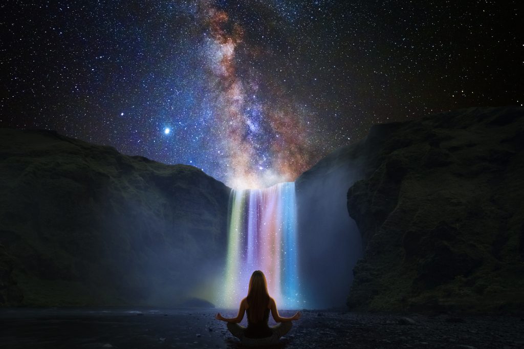 Yoga by rainbow waterfalls at night